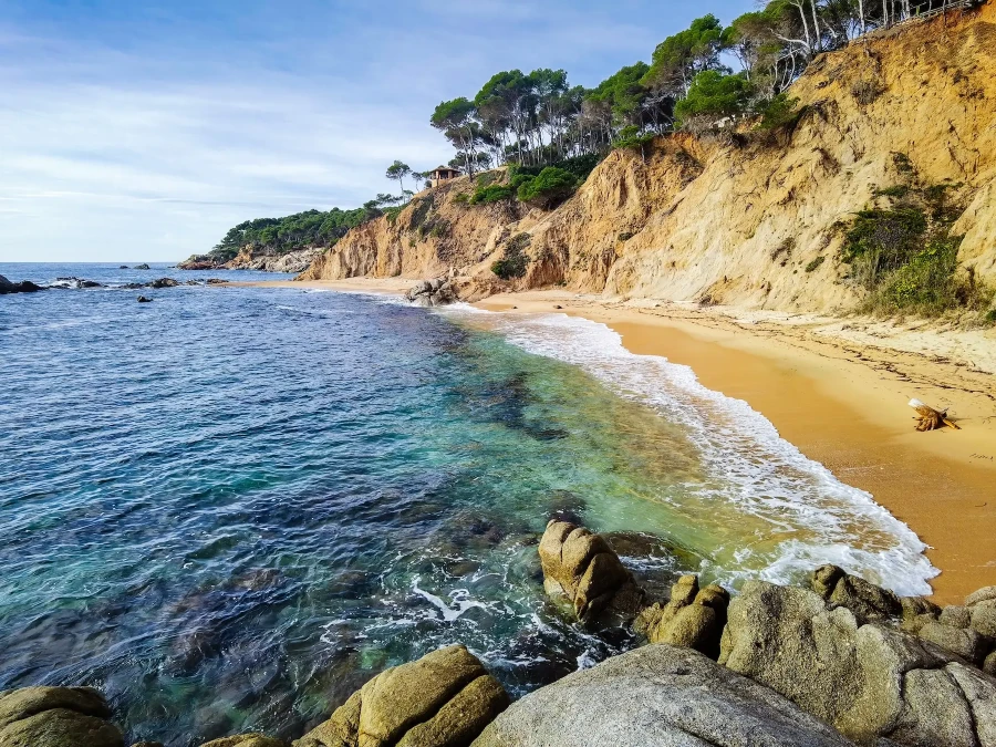A deserted cove with a sandy beach and turquoise sea