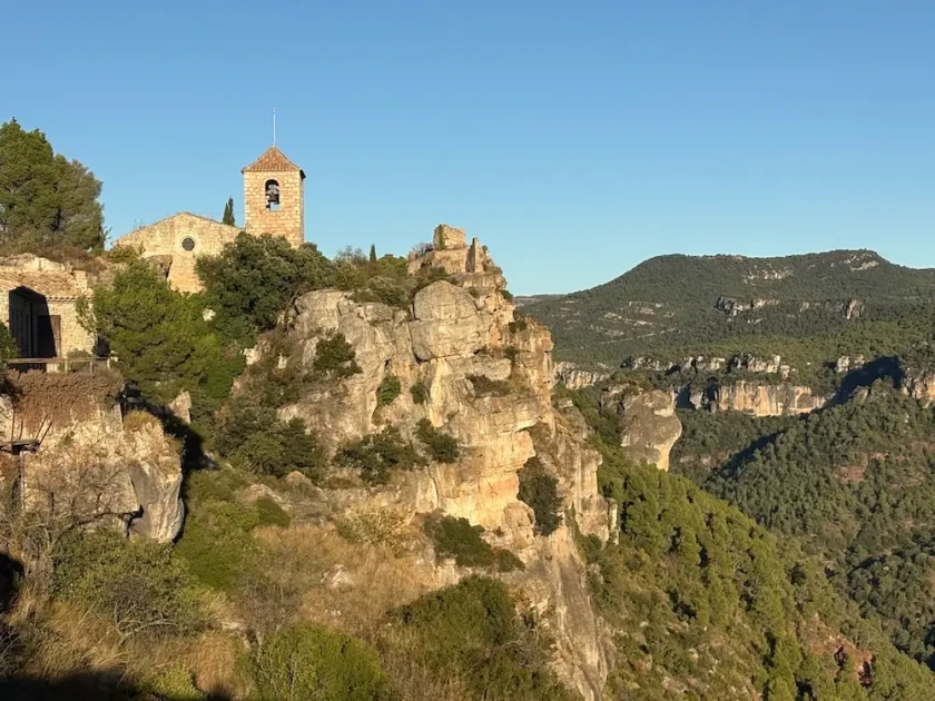 The church of siurana in the priorat on its cliff with Montsant mountains in the distance