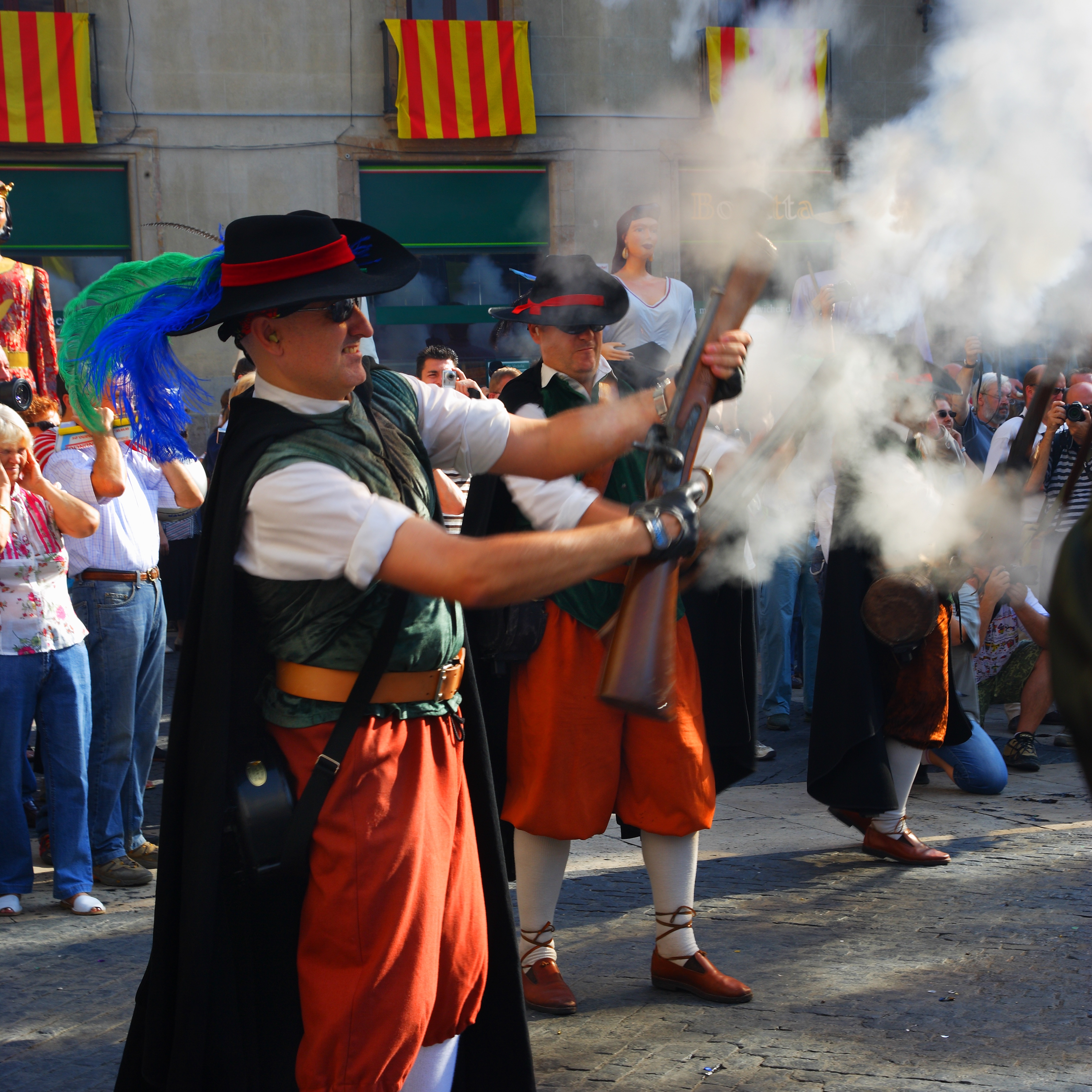 Men in traditional costume firing blunderbusses at a festival